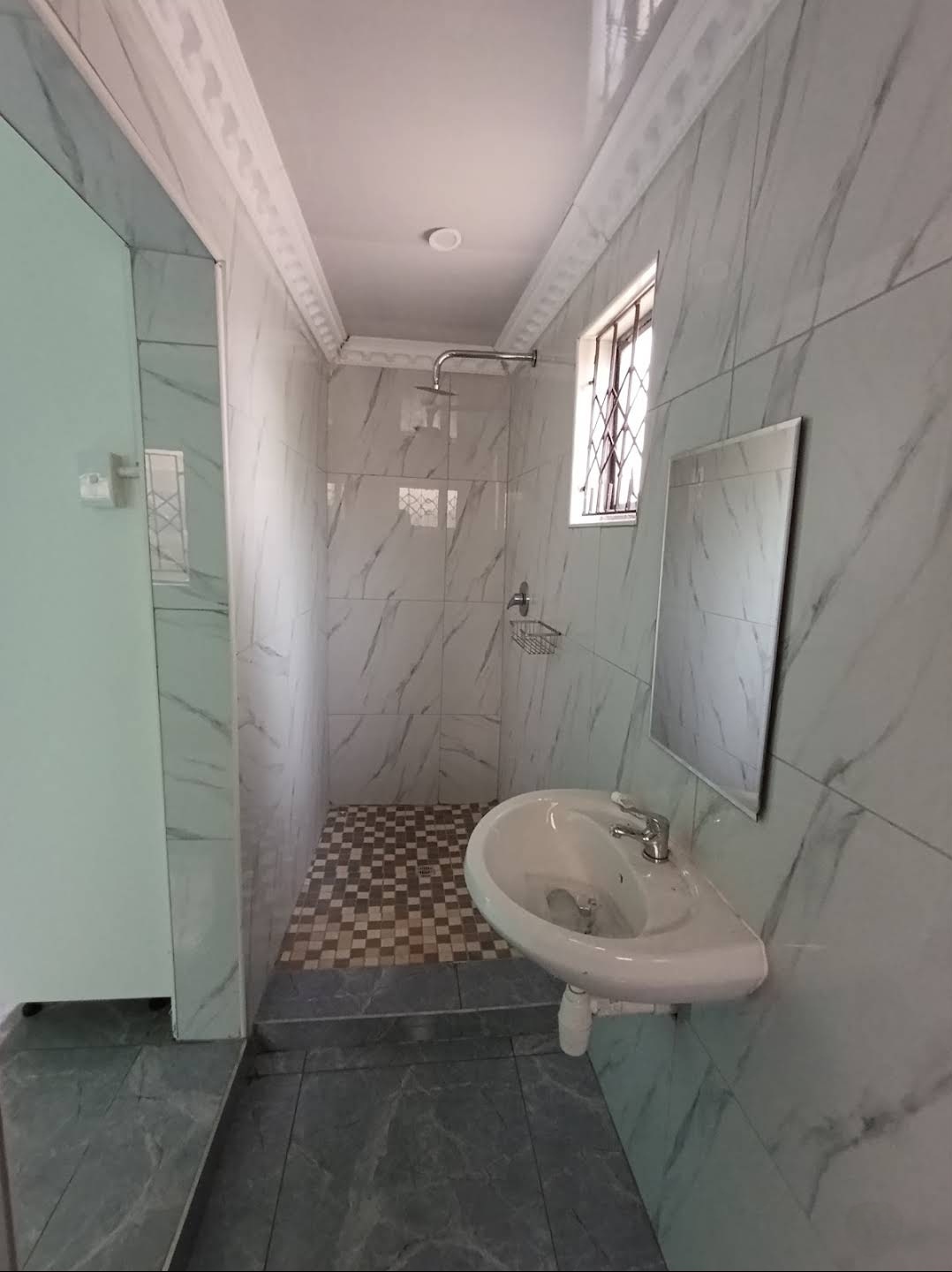 Marble-tiled bathroom with walk-in shower